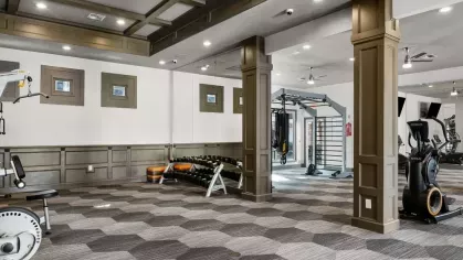 A spacious fitness area with advanced exercise equipment and stylish geometric carpeting.