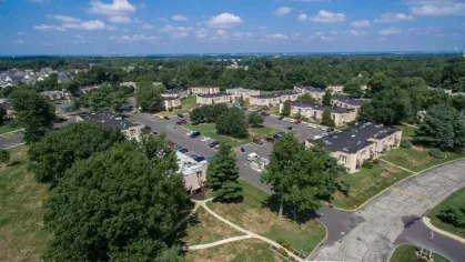 Aerial view of Forest Creek Apartments community surrounded by lush greenery, ample parking, and walking paths
