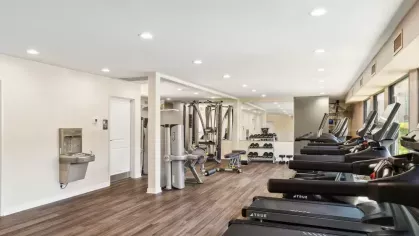 Spacious gym with modern equipment, free weights, and a water filling station.