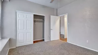 Bedroom with closet, neutral carpet, and ceiling fan
