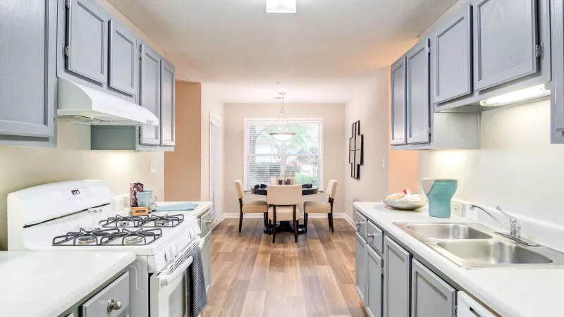 Bright dining area adjacent to the kitchen, with natural light from a large window.
