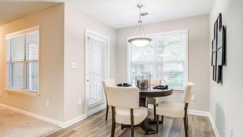 Cozy dining nook with a round table and four chairs under a pendant light.