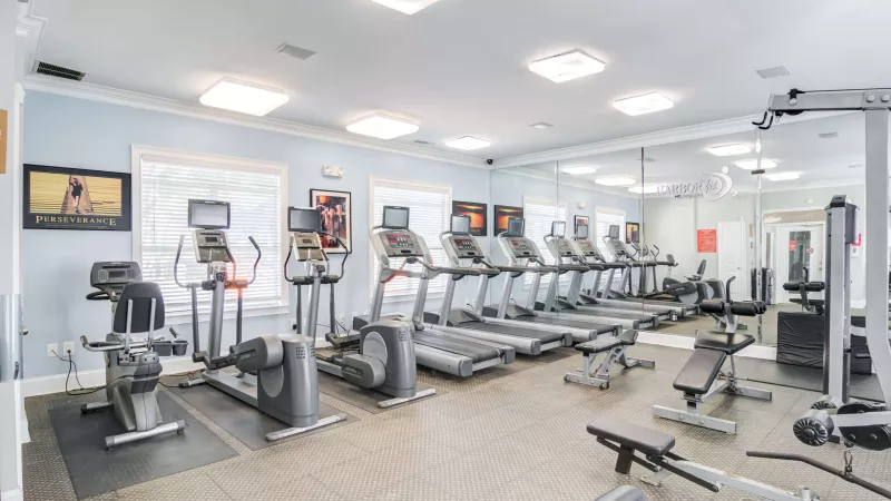 On-site fitness center featuring treadmills, ellipticals, strength machines, and mirrors.