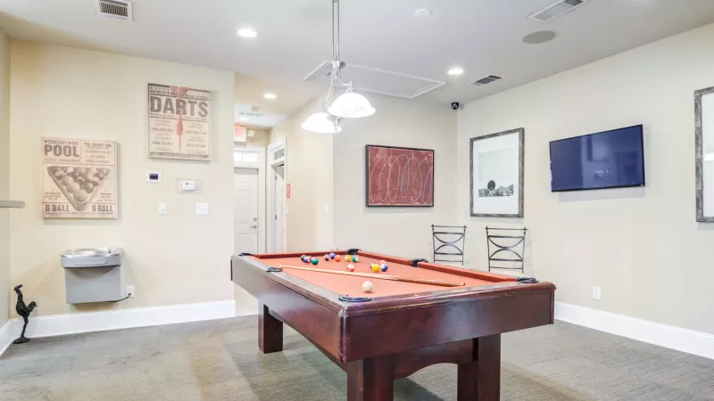 Game room featuring a pool table, TV, and artwork on the walls.