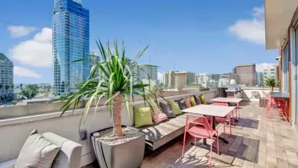 A spacious outdoor patio with string lights, modern furniture, and a built-in kitchen area, creating a perfect social setting.