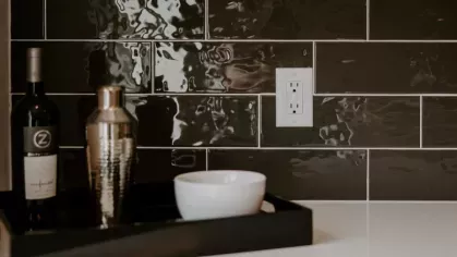 Close-up of a chic black subway tile backsplash with a decorative bar tray, highlighting the high-end finishes in Industry Columbus Apartments.