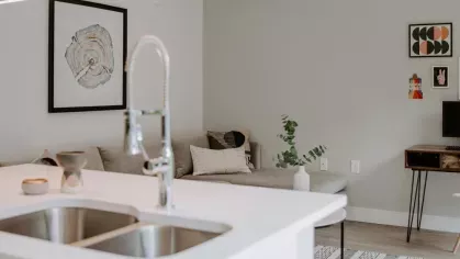 A view from the kitchen looking into the living space, featuring a cozy seating area, stylish décor, and modern pendant lighting.