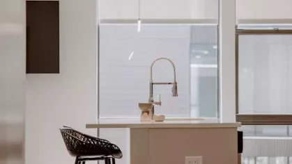 A modern kitchen at Industry Columbus Apartments featuring white cabinetry, stainless steel appliances, and a sleek island with bar seating.