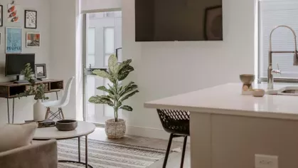 A contemporary kitchen with stainless steel appliances, a dark subway tile backsplash, and a large island with seating.