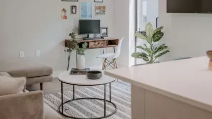 A bright and airy kitchen with a waterfall island, high-end finishes, and a view of the apartment’s open living space.