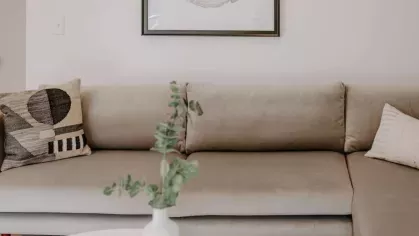 A cozy living area with a sectional sofa, stylish artwork, and a sleek coffee table complementing the apartment’s modern aesthetic.