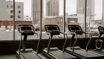 A gym with a stunning city view, featuring treadmills overlooking the Columbus skyline, making workouts at Industry Columbus Apartments both motivating and scenic.