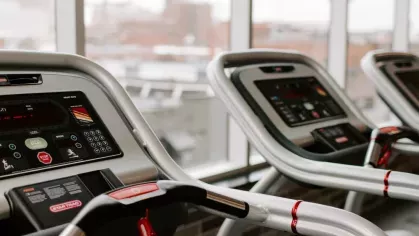 Modern treadmill equipment in a well-lit gym with city views at Industry Columbus Apartments.
