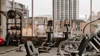 Expansive fitness center featuring ellipticals and resistance training equipment with downtown Columbus skyline views.