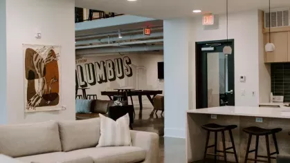 A view of the open lounge area with a spacious kitchen, bar seating, and a billiards table, offering multiple entertainment options.