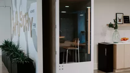 A contemporary seating area at Industry Columbus Apartments with tiered wooden benches, colorful cushions, and a cozy coffee table for a relaxed community atmosphere.