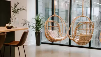 A contemporary resident lounge at Industry Columbus Apartments with plush seating, a large TV, and floor-to-ceiling windows overlooking the vibrant cityscape.