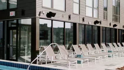 A glass-enclosed workspace adjacent to a fitness center at Industry Columbus Apartments, providing a quiet and stylish setting for work or study.