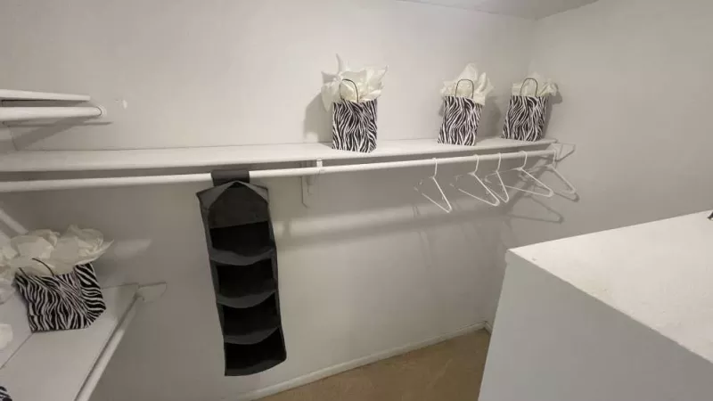 A spacious walk-in closet featuring built-in shelving, ample hanging space, and decorative storage bags for an organized and clutter-free living experience.