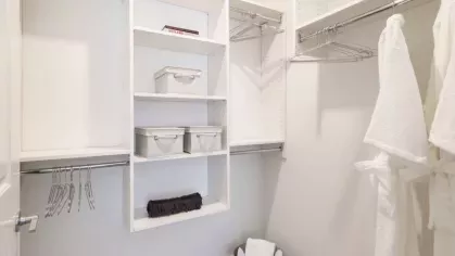 A spacious walk-in closet with built-in shelving, plush carpeting, and ample storage space for an organized lifestyle.