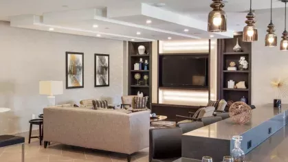 A contemporary lounge area with elegant seating, warm lighting, and a sleek entertainment center.