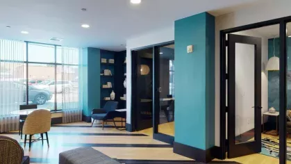 A chic coworking space with floor-to-ceiling windows, stylish furnishings, and private work pods.