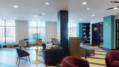 A spacious resident lounge with vibrant seating, modern decor, and ample natural light.