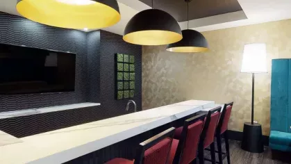 A trendy bar area with high-top seating, stylish pendant lighting, and a sleek countertop.
