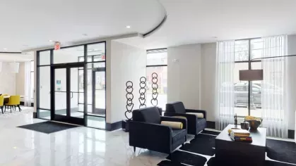 A luxurious lobby with marble flooring, plush seating, and an elegant entranceway.