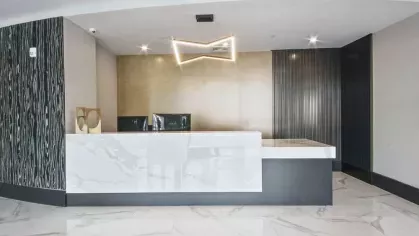 A contemporary reception area with high-end finishes, geometric lighting, and an inviting ambiance.