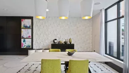 A stylish community lounge with plush seating, accent lighting, and a mounted flat-screen TV.