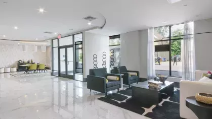 A well-lit co-working space with floor-to-ceiling windows, modern furnishings, and a collaborative atmosphere.