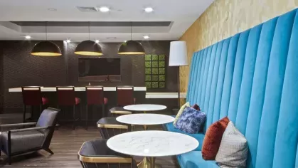 A welcoming seating area with modern artwork, plush furniture, and floor-to-ceiling windows.