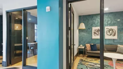 A bright and airy lobby featuring a marble reception desk, designer lighting, and stylish decor.
