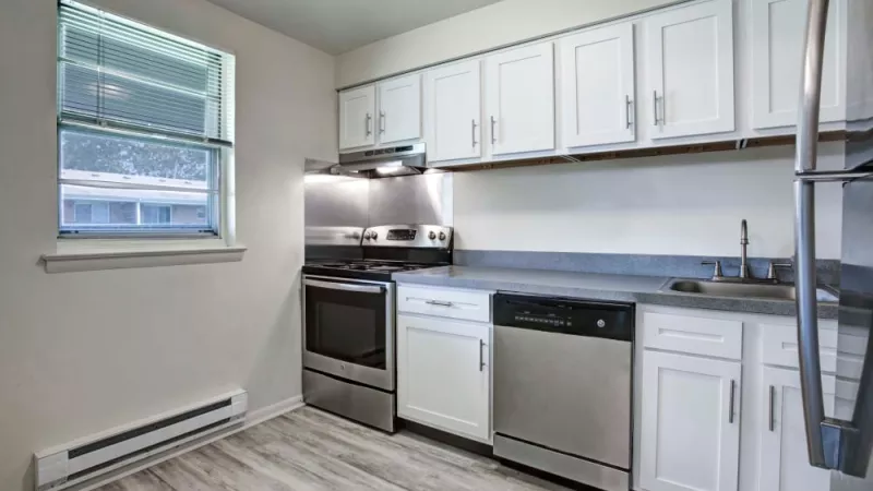Updated kitchen with white cabinetry, stainless steel appliances, and a contemporary design at Silver Lake Manor Apartments.