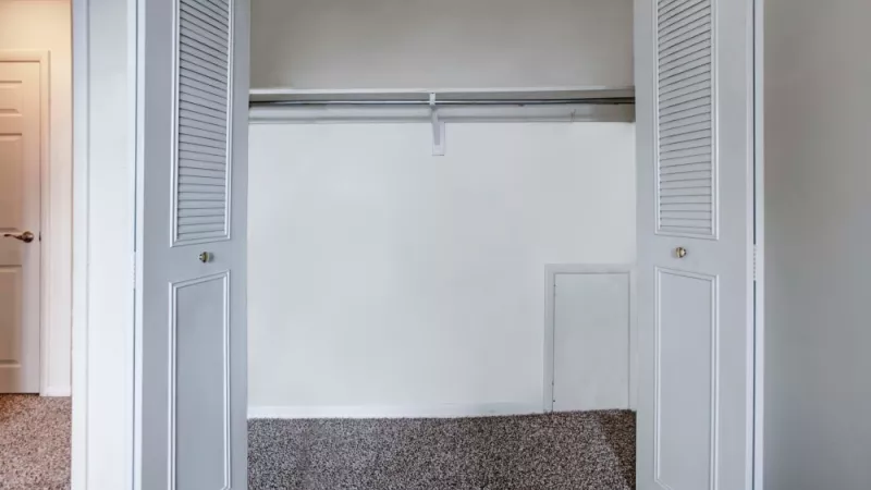 A roomy bedroom closet with double doors, ample hanging space, and shelving for convenient storage solutions.