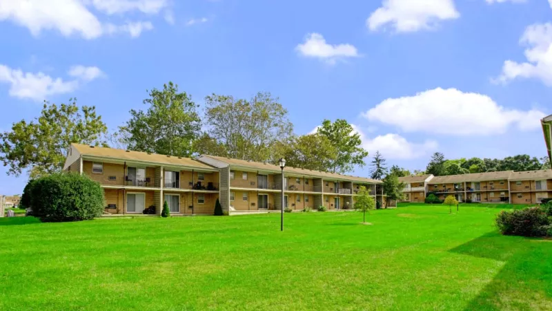A scenic view of Silver Lake Manor’s well-manicured green lawns, surrounded by two-story apartment buildings with private balconies.