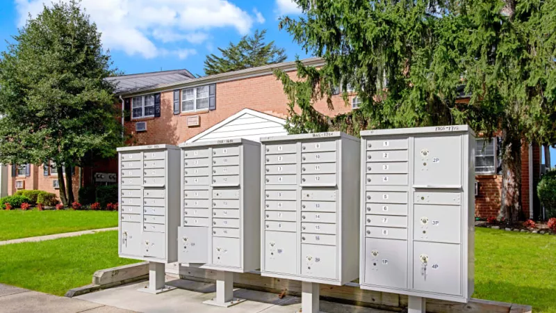 A set of secure mailboxes outside the apartment buildings, providing convenient and organized mail storage for residents.