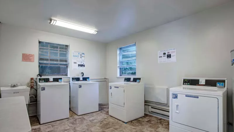 A clean and well-maintained laundry room equipped with multiple washers and dryers, ensuring hassle-free laundry days for residents.