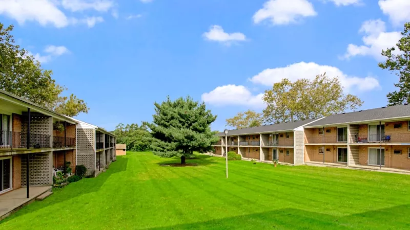 Expansive green lawn between two residential buildings at Silver Lake Manor Apartments, providing a peaceful and spacious outdoor area for residents.