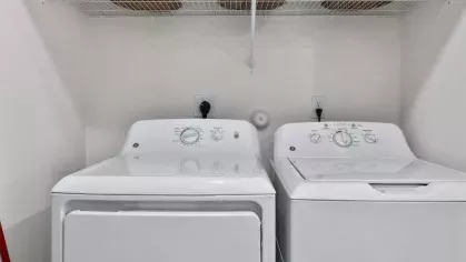  A functional laundry space with a washer, dryer, and woven storage baskets.