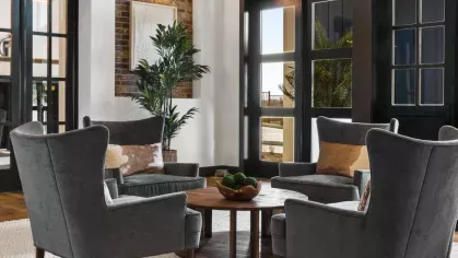 A grand community lounge with high ceilings, sophisticated seating, and warm, inviting decor.
