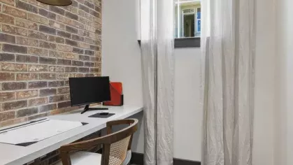 A stylish co-working lounge featuring plush seating, a coffee station, and warm pendant lighting.