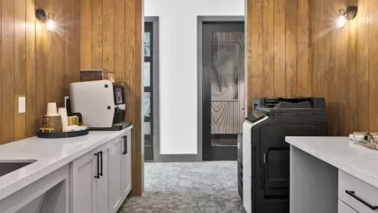 A cozy private workspace with an exposed brick accent wall, modern desk, and natural light.