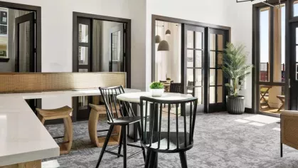 A business center with sleek wood-paneled walls, coffee bar, and high-end printing equipment.