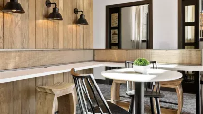 A bright communal workspace with vaulted ceilings, modern furniture, and ample natural light.