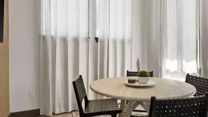 A modern collaborative workspace with sleek decor, warm lighting, and stylish black chairs.