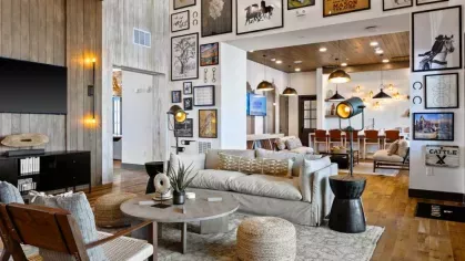 A chic coffee station with an espresso machine, rustic stone wall, and warm ambient lighting.