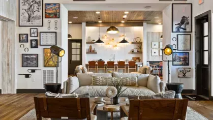 A luxurious lounge with high ceilings, curated artwork, and a blend of rustic and modern decor.
