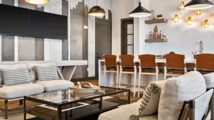 A sophisticated entertainment lounge with plush seating, warm wood accents, and industrial lighting.